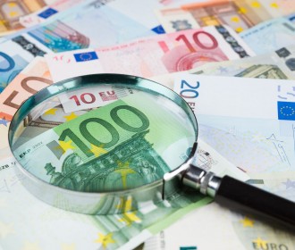 Finansų rinkos dalyvių priežiūra-padidinamasis stiklas ant banknotų.jpg